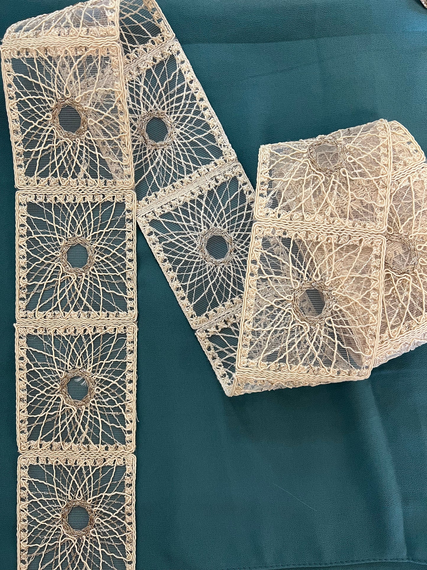 Galon type dentelle à motifs géométriques carrés et rosaces.