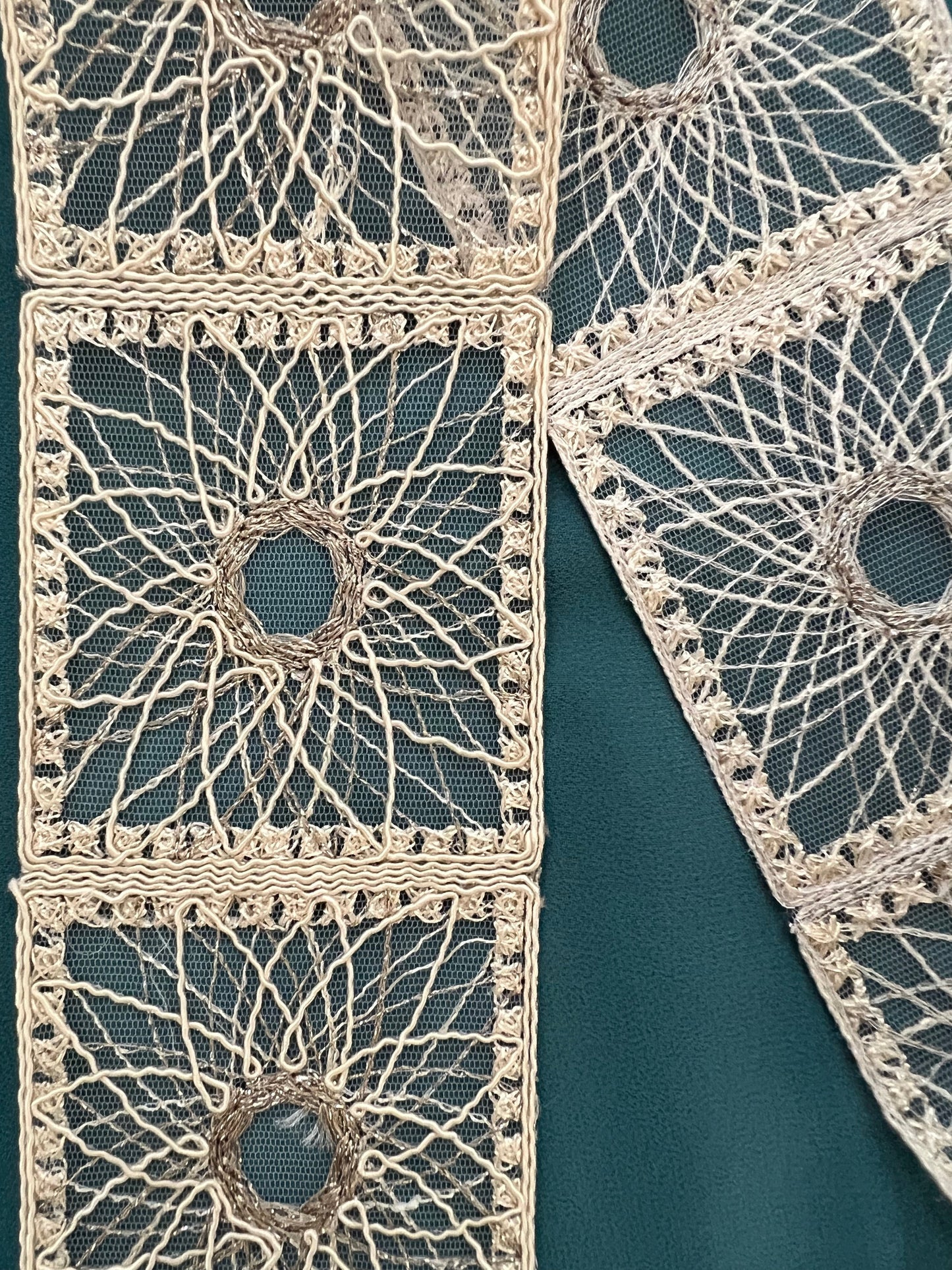 Galon type dentelle à motifs géométriques carrés et rosaces.