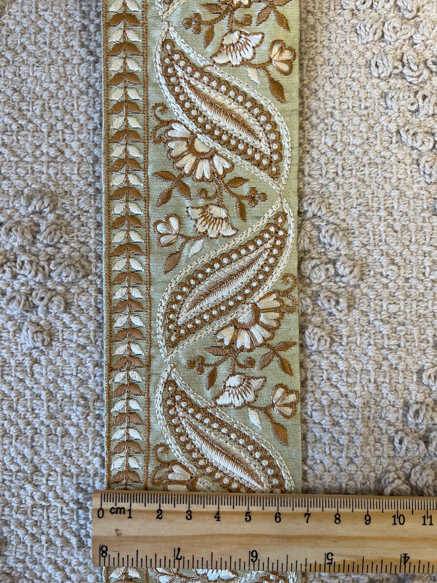 Galon vert à broderie blanche et fils dorés.