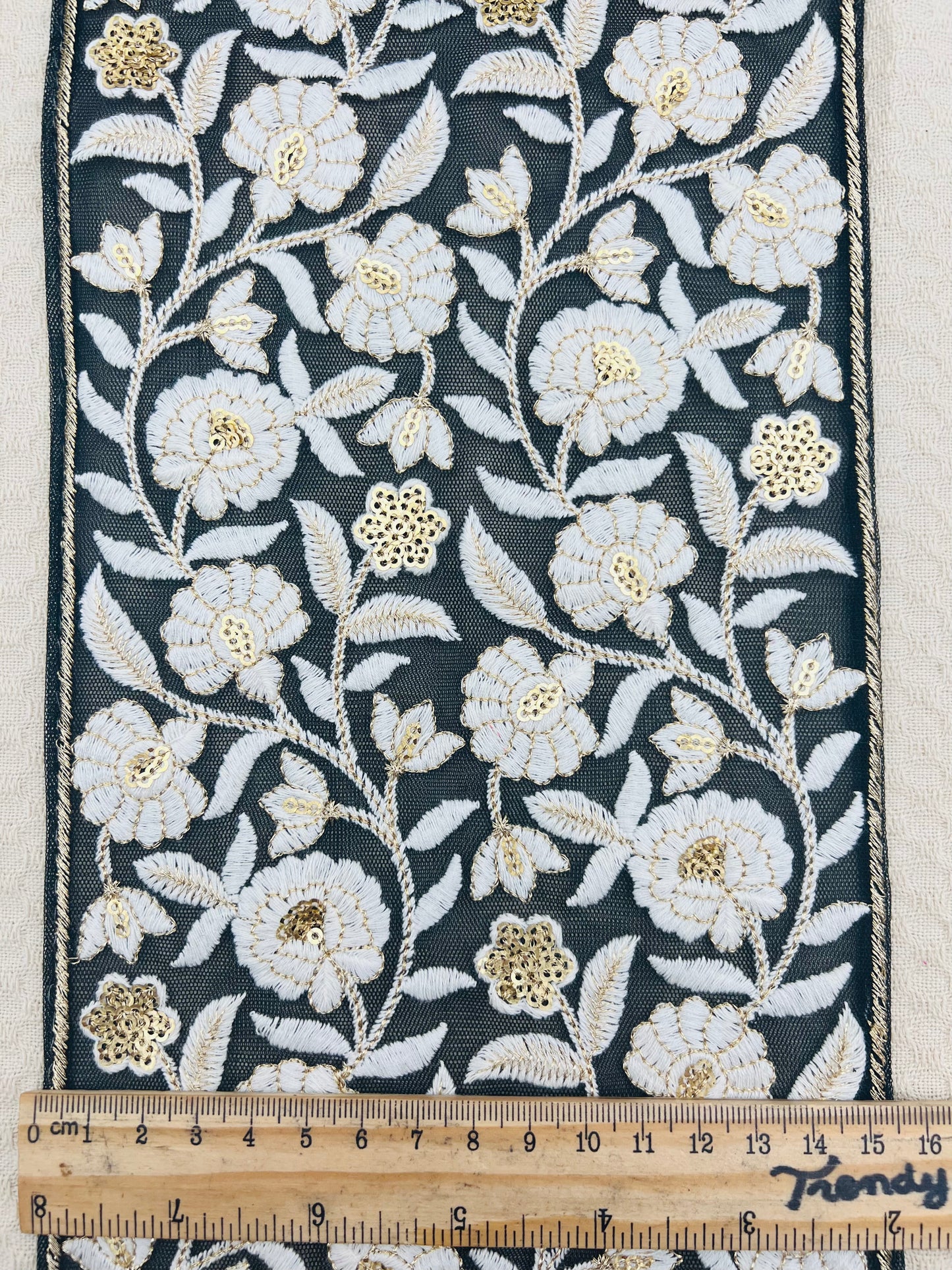 Galon large brodé floral blanc et doré sur fond noir transparent