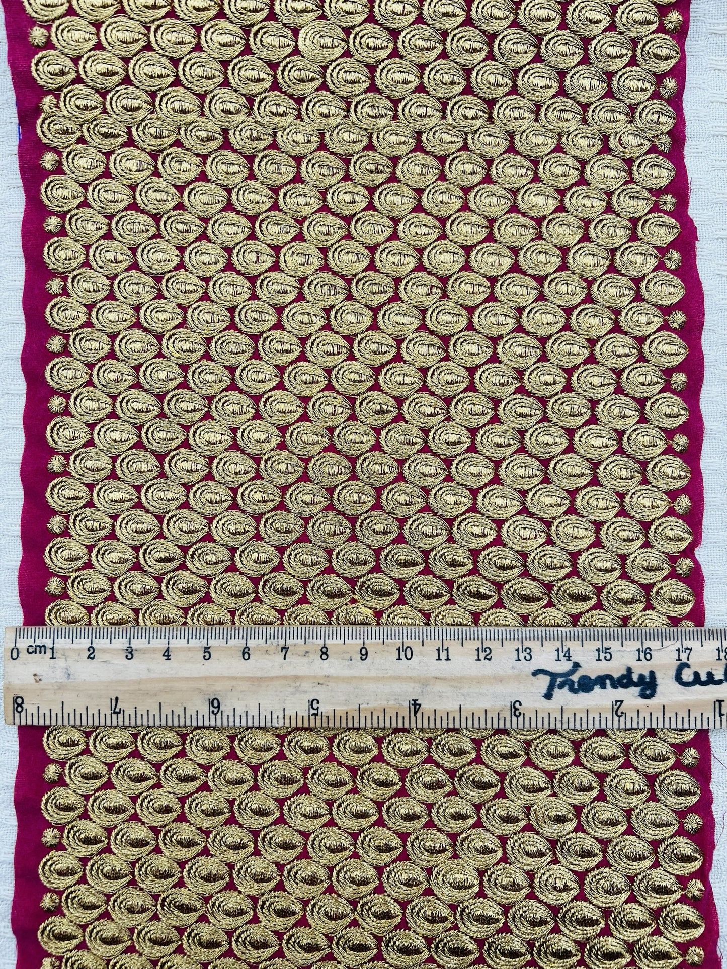 Galon extra large brodé doré sur fond fuchsia