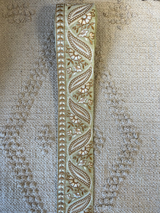 Galon vert à broderie blanche et fils dorés.