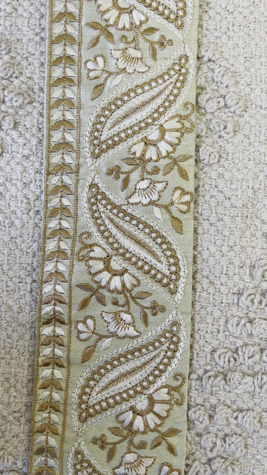 Galon vert à broderie blanche et fils dorés.